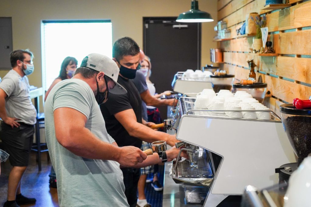 Students using espresso equipment at Texas Coffee School's barista training
