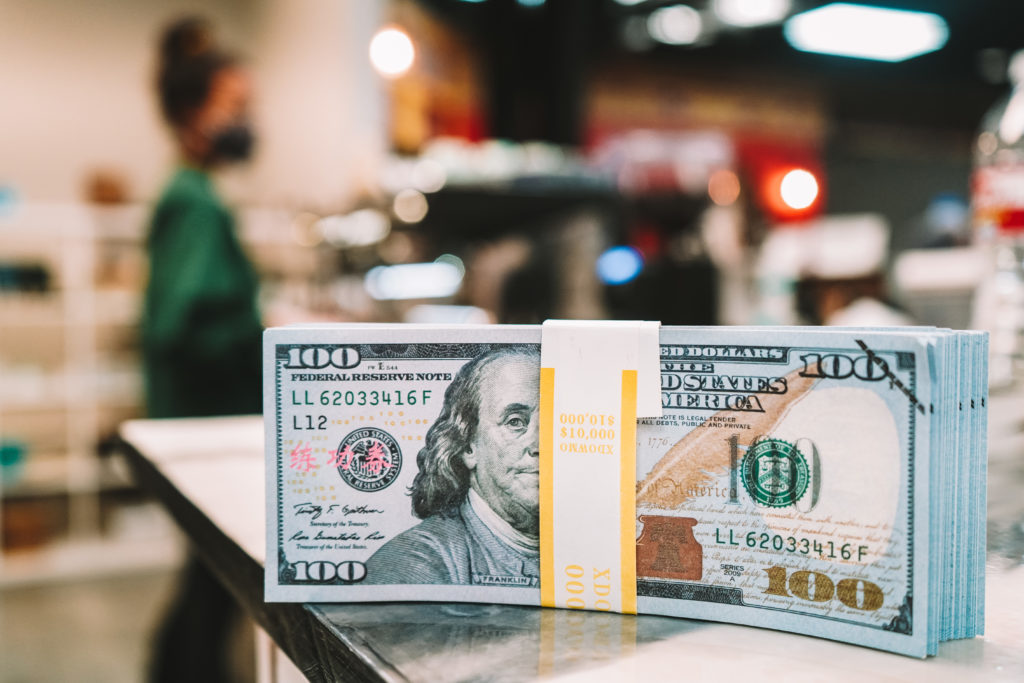 hundred dollar bills on coffee shop counter