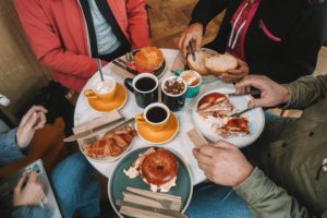 people eating bagels and coffee around a table