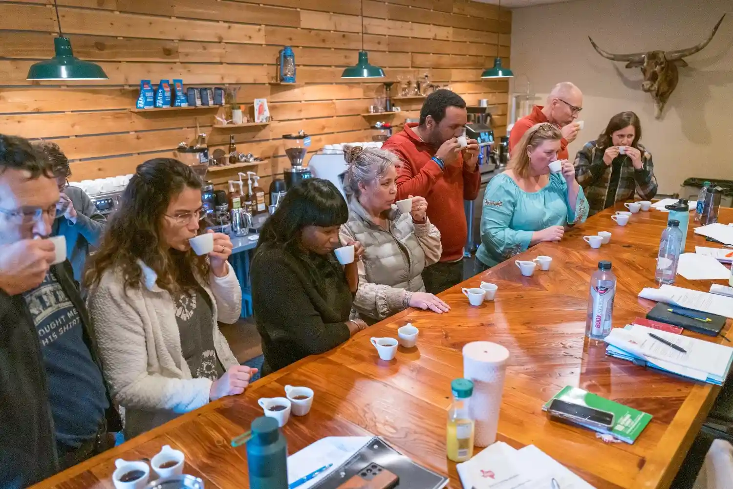 Students taste different types of coffee at a coffee shop business class.