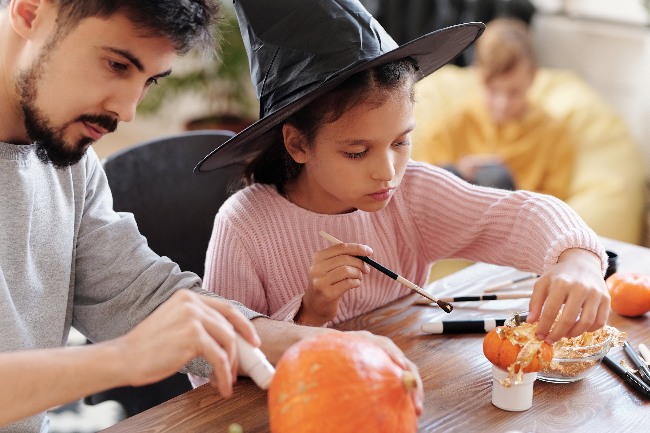 A family at a pumpkin-painting event.