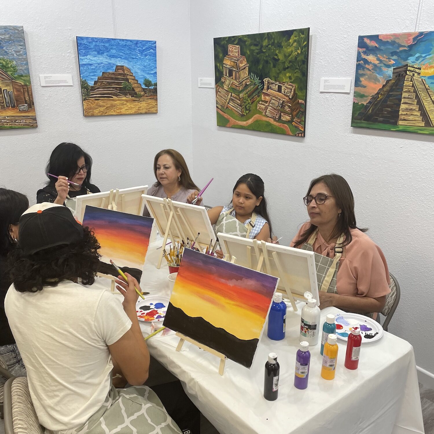 A painting class with art in the background at Kreative Grounds Cafe.