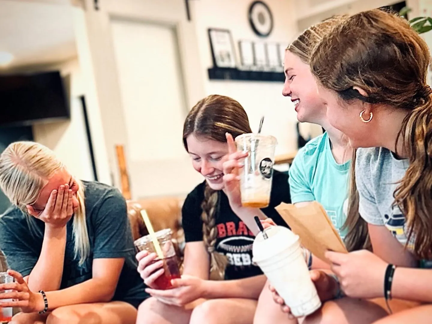 Friends laugh at a coffee shop.