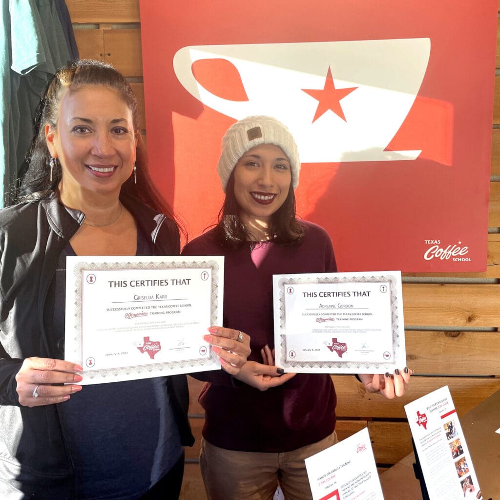 Kris and Adrienne holding certificates from Texas Coffee School 